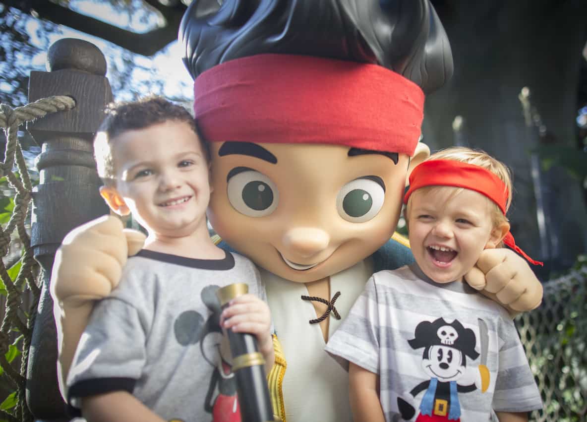 Two boys smiling with a playful pirate
